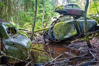 Gestapelte Autowracks im Wald bei Bastnas in Schweden