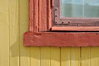 Fensterrahmen des Holzhauses in gelb und rot