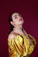 Portrait of a Woman with Golden Satin Blouse and Red Background