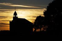 Silhouet van kerkje tijdens zonsondergang