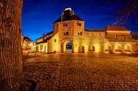 Einbruch der Nacht mit blauem Himmel und langer Belichtung über einem alten Stadttor in der Nähe der