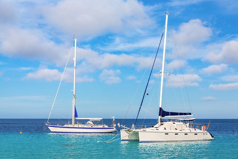 Two sailboats float at sea on the coast of Bonaire by Ben Schonewille