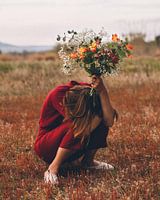 Girl squatting with flowers