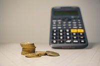 Pièces de monnaie, en arrière-plan Calculatrice