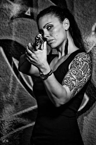 Tattooed woman with a pistol in black and white by Atelier Liesjes