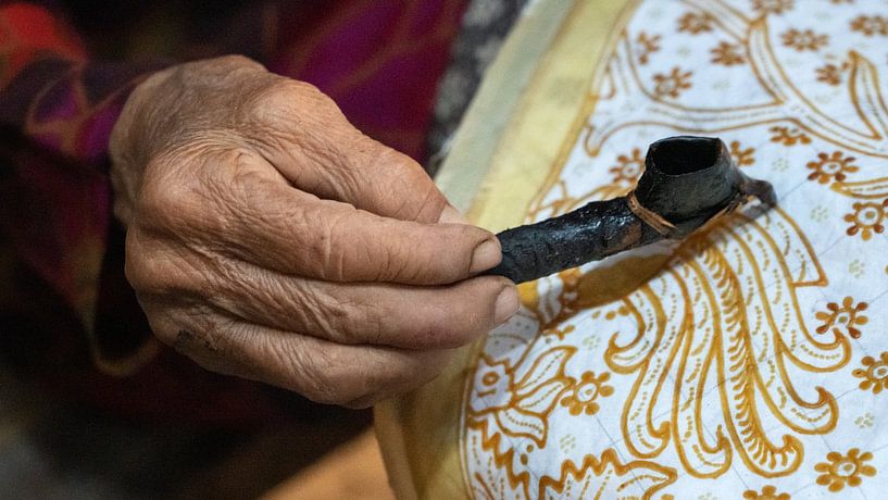 Hand of an elderly batik artist by Anges van der Logt