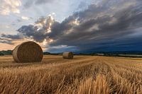 Heuballen auf dem Feld mit dramatischen Wolken