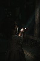 Zaubern. Kleines Mädchen spielt mit Stoff und einem Sonnenstrahl