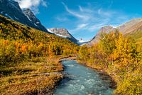 Fluss durch ein Tal mit Gletscher im Hintergrund.