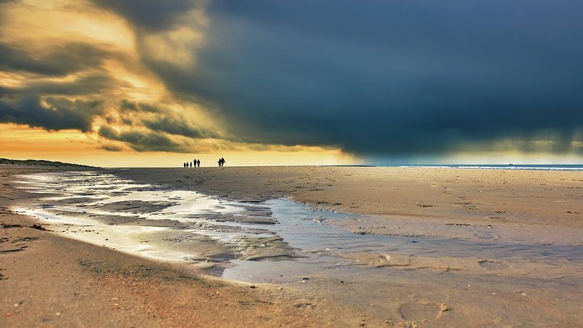 Nuages sombres avec des promeneurs sur la plage par eric van der eijkj