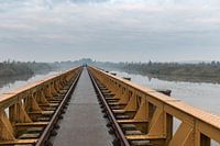 Two joggers running on abandoned railway bridge at Moerputten, Netherlands