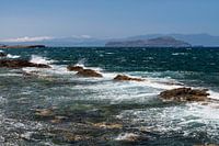 Vergezicht over de zee met rotsen in de branding