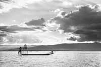 Zwart-wit foto van een visser met zijn visnetten op de boot op het Inle meer in Myanmar