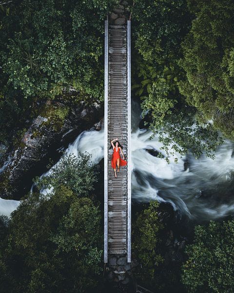 Brücke über strömenden Wasser Frau mit rotem Kleid von Daniel Kogler
