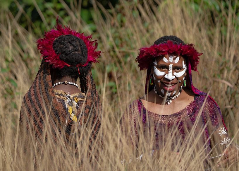 Beautifully made-up Dani girls in the tall grass by Anges van der Logt