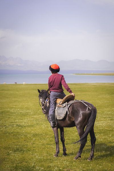 Junge kirgisische Reiterin blickt über den Soň-Köl-See von Mark Sluijmers