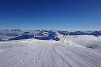 Skipiste in Kitzbühel, Tirol (Österreich), umgeben von Berggipfeln und Wolken