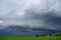 Rolwolk met veel neerslag en een dorp