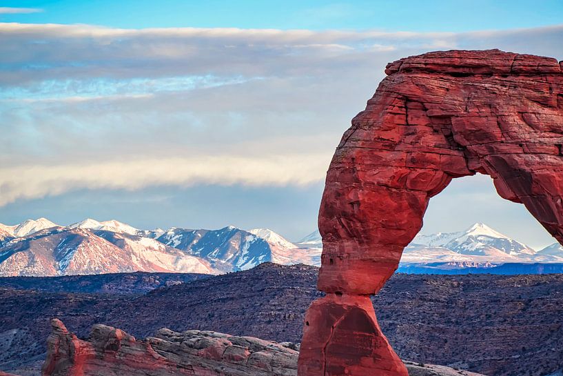 Die schneebedeckten Gipfel der Rocky Mountains hinter dem Delicate Arch von Rietje Bulthuis