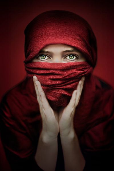Eindringliches Foto einer Frau mit rotem Schleier - kraftvoller Blick mit grünen Augen von Elianne van Turennout