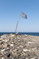 Greek flag on pebble beach near the sea