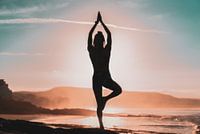 Woman does yoga on the beach