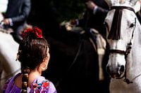 Spanisches Mädchen kommuniziert mit weißem Pferd