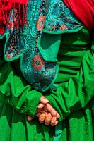 Interlocked hands in detail of bright green attire