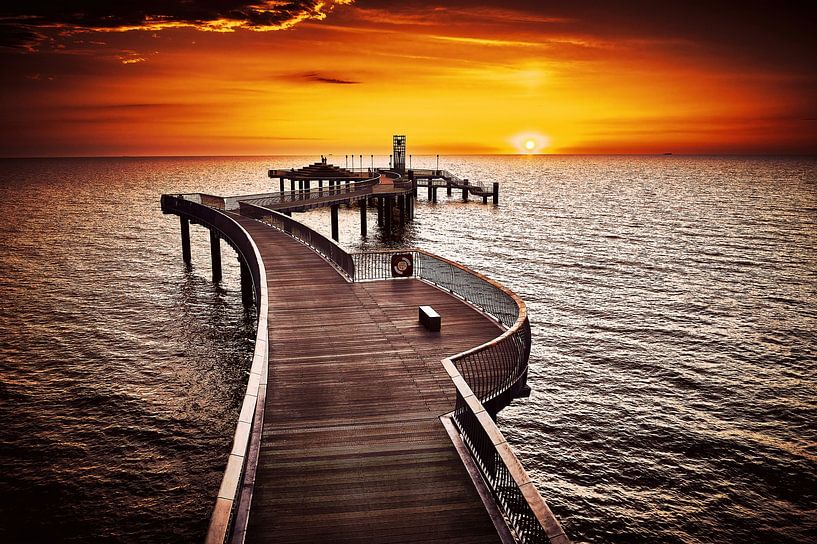 Sunrise behind the curved Koserow pier on the island of Usedom bathed in a golden hue by Stefan Dinse
