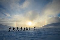 Rugzaktrekkers voor de zon met een halo