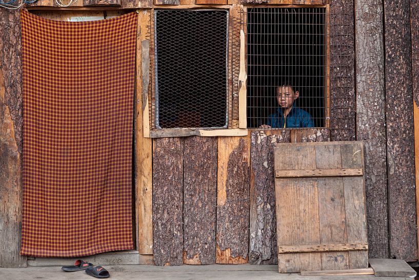 Boy behind open window in hut near Thimphu Bhutan. Wout Kok One2expose by Wout Kok