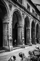 Man loopt door portici in Bologna, Italië