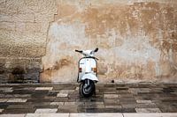 White scooter in front of a historic wall