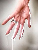 Vrouwenhand met druppelende muurverf