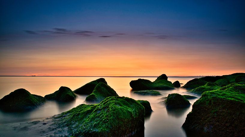 The rocks during sunset at the outlet of Katwijk aan Zee by Wim van Beelen