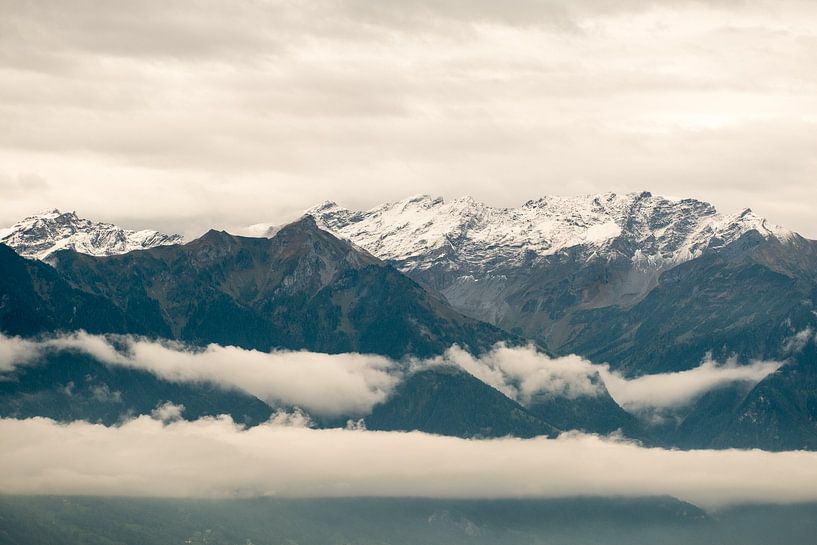 Des nuages entre les sommets enneigés. par Idema Media