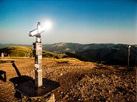 the sun bounces back from binoculars at the top of a mountain in the Vosges mountains