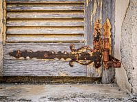 Alter hölzerner Fensterladen mit verrostetem Scharnier