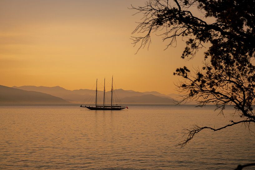 Un bateau, un paysage de mer et de montagne à l'aube par Leo Schindzielorz