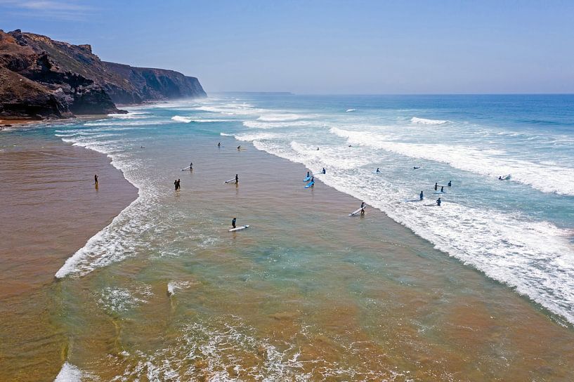 Vue aérienne de la plage de Vale Figueiras sur la côte ouest du Portugal, remplie de surfeurs. par Eye on You
