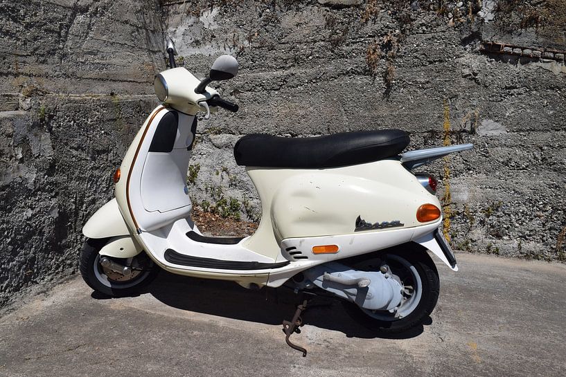 White classic Vespa scooter in the Italian sun against stone wall by Studio LE-gals