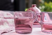 Set of pink tea glasses with liquid for a particularly pink background with a vase