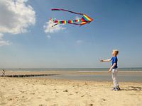 Jongen met vlieger op het strand