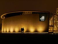 Two People Walk In Front of Van Gogh Musuem at Night