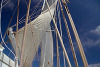 weiße Segel, Seile als Netz vor blauem Himmel