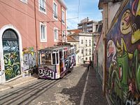 Alte Straßenbahn und Graffiti in einer Gasse in Lissabon