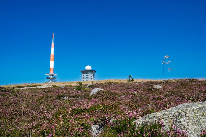 Contraste entre l'ingénierie humaine et la beauté naturelle avec le mât émetteur orange-blanc sur l'emblématique Brocken par RAW & Refined