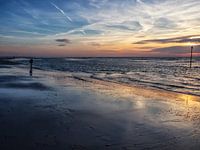 Wandelaar aan zee tijdens zonsondergang in Kijkduin, Den Haag