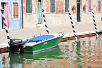 Motorboot en gekleurde huizen op Burano (Venetië , Italië)