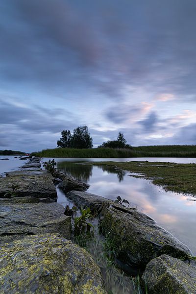 Nuages sombres et menaçants au-dessus d'un barrage en pierre sur le lac Amstel par Bram Lubbers